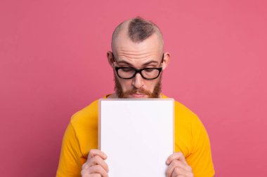Fun young man look out eyes white empty blank billboard for promotional content isolated studio shot