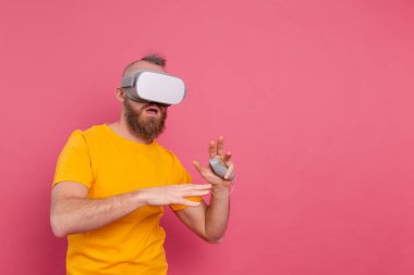 Korkmuş oyuncunun portresi, stüdyo arka planında VR gözlük takan tişörtlü sakallı adam.