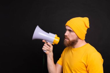 Serious european man with megaphone on black background