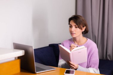 Woman at home with notepad notebook thinking about plans