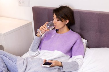 Woman at home bored tired fell sleep with glass of wine and phone in han