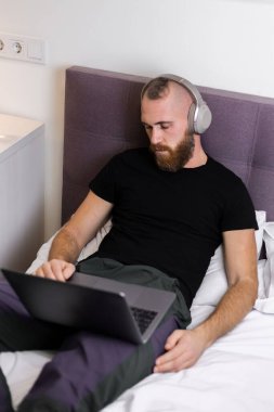 Man in bedroom on bed fell asleep in front of lapto