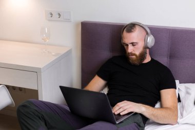 Man in bedroom on bed fell asleep in front of lapto