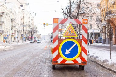Şehir caddesinde karlı bir yolun kenarındaki yol işleriyle ilgili uyarı levhası