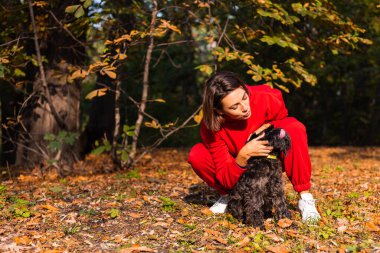 Sabah erkenden. Mutlu kadın uykulu gözler parkta köpek, sonbahar turuncu renkler.