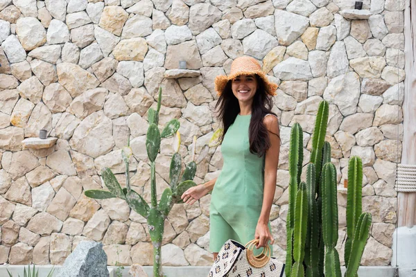 Zarif yeşil elbise içinde şık, mutlu, gülümseyen bir kadının portresi.