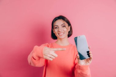 Şu cep telefonuna bak! Mutlu kadın işaretleri boş ekrana işaret ediyor, modern aletler gösteriyor, mutlu ve şaşırmış duygular..