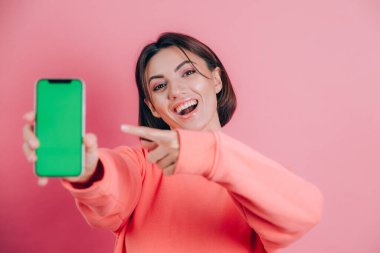 Şu cep telefonuna bak! Mutlu kadın işaretleri boş ekrana işaret ediyor, modern aletler gösteriyor, mutlu ve şaşırmış duygular..