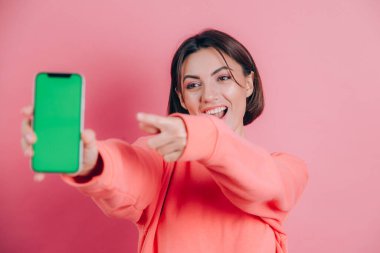 Şu cep telefonuna bak! Mutlu kadın işaretleri boş ekrana işaret ediyor, modern aletler gösteriyor, mutlu ve şaşırmış duygular..