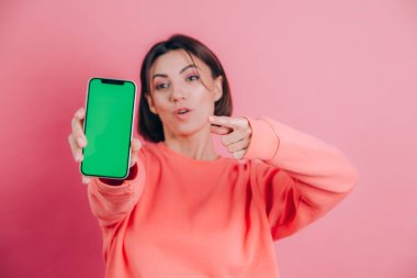 Şu cep telefonuna bak! Mutlu kadın işaretleri boş ekrana işaret ediyor, modern aletler gösteriyor, mutlu ve şaşırmış duygular..