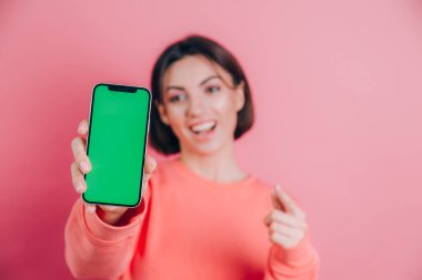 Şu cep telefonuna bak! Mutlu kadın işaretleri boş ekrana işaret ediyor, modern aletler gösteriyor, mutlu ve şaşırmış duygular..