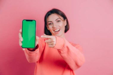 Şu cep telefonuna bak! Mutlu kadın işaretleri boş ekrana işaret ediyor, modern aletler gösteriyor, mutlu ve şaşırmış duygular..