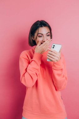 Heyecanlı genç bir kadın, akıllı telefona bakıp, cep telefonundan neşe içinde bağıran inanılmaz bir alışveriş uygulaması satışı mesajına hayran kaldı. 