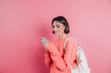 Akıllı telefonu olan genç ve güzel bir kadın. Gülümseyen öğrenci kız seyahate çıkıyor..