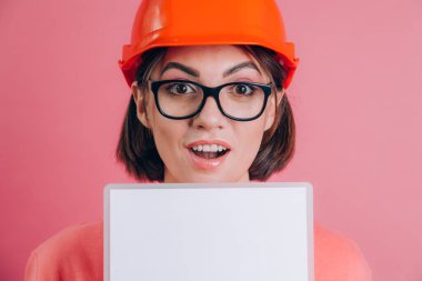 İşçi kadınların beyaz tabelayı pembe arka planda tutmasına çok şaşırdım. Miğfer inşa ediliyor. 