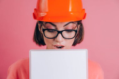 İşçi kadınların beyaz tabelayı pembe arka planda tutmasına çok şaşırdım. Miğfer inşa ediliyor. 