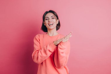 Arka planda rahat bir süveter giyen, alkışlayan mutlu ve neşeli, gururlu elleri bir arada tutan bir kadın.