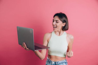 Pembe arka plandaki kadınlar diz üstü bilgisayarı tutuyor.