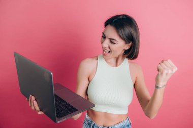 Pembe arka plandaki kadınlar diz üstü bilgisayarı tutuyor.