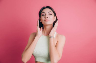 Pembe arka planda kameraya gülümseyen bir kadın. Pozitif kişi.