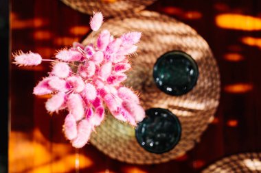 Kafedeki ahşap masada pembe çiçek süslemeli meyve suları.