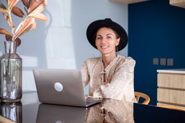 Giyinik Avrupalı bir kadın ve mutfakta klasik şapka işi.