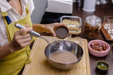 Aşçı mutfakta badem sütü, kakao ve chea tohumlarını karıştırıyor.
