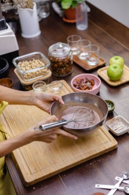 Aşçı mutfakta badem sütü, kakao ve chea tohumlarını karıştırıyor.