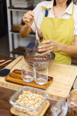 Kadın mutfakta chia pudingi hazırlıyor, alt tabakayı hazırlıyor.