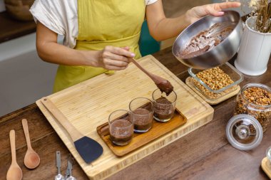 Kadın mutfakta chia pudingi hazırlıyor, alt tabakayı hazırlıyor.