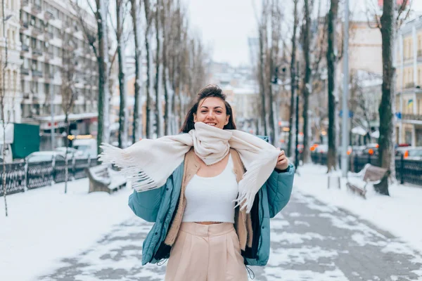 Happy woman in winter on snowy city alley