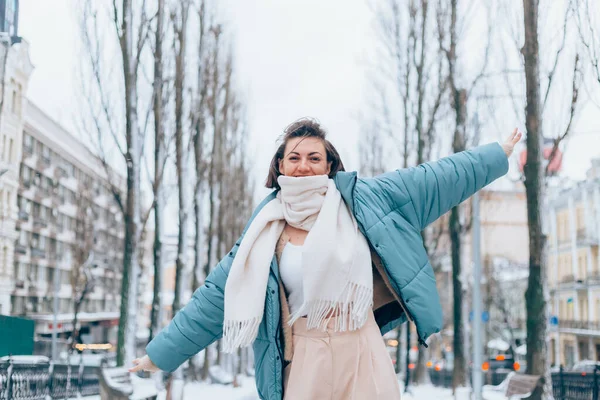 Happy woman in winter on snowy city alley