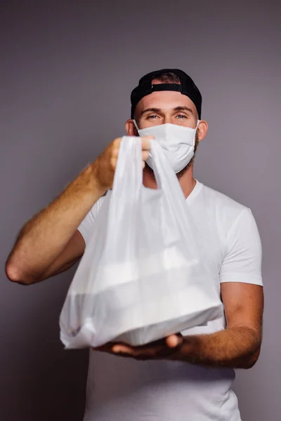 stock image deliver man wearing face medical mask handling plastic bag of food