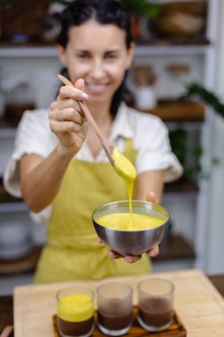 Mutfaktaki kadın mangolu puding yapıyor.