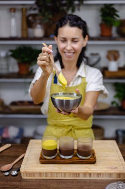 Mutfaktaki kadın mangolu puding yapıyor.