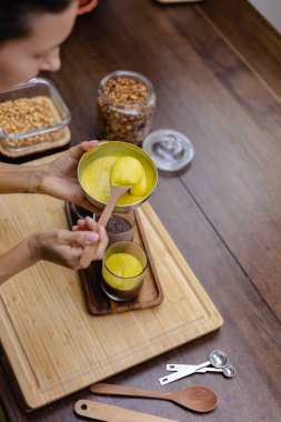 Mutfaktaki kadın mangolu puding yapıyor.