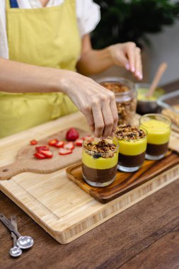 Mutfaktaki kadın mangolu puding yapıyor.