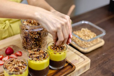 Mutfaktaki kadın mangolu puding yapıyor.