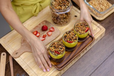 Mutfaktaki kadın mangolu puding yapıyor.