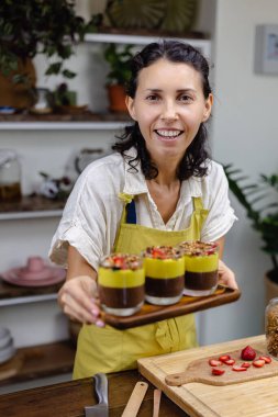 Mutfaktaki kadın mangolu puding yapıyor.