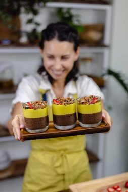 Mutfaktaki kadın mangolu puding yapıyor.