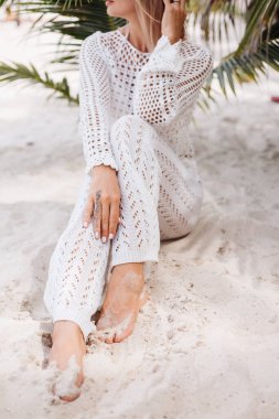 Kumsalda örülmüş beyaz elbiseli bir kadın.