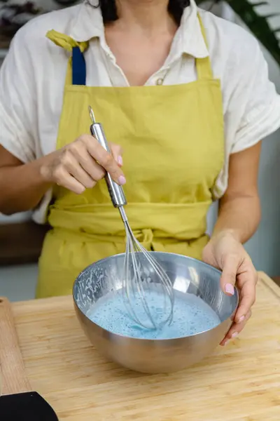 Kadın badem sütü, chia tohumu ve mavi spirulina ekstratı karıştırıyor, doğal renk.