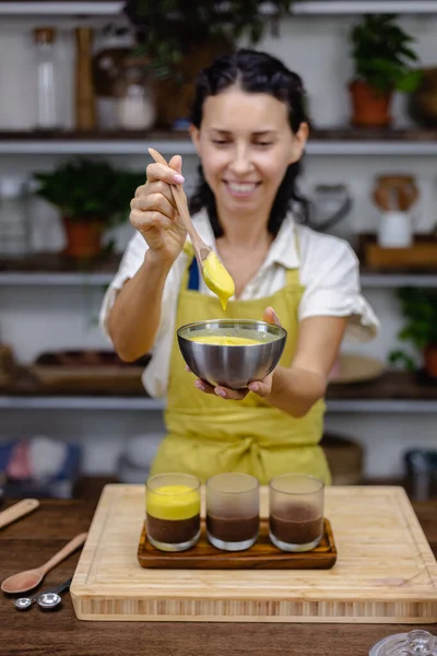 Mutfaktaki kadın mangolu puding yapıyor.