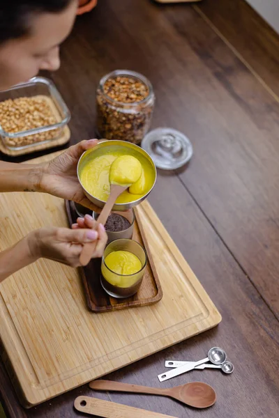 Mutfaktaki kadın mangolu puding yapıyor.