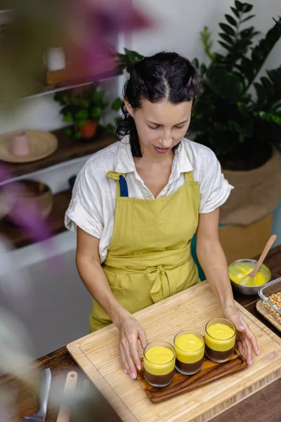 Mutfaktaki kadın mangolu puding yapıyor.