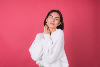 Pembe arka planda beyaz süveter giyen güzel bir kadın. Aşk kavramı. El ele tutuşup kendini kopyalanmış fotokopi odası kapalı gözlerle kucaklıyor.