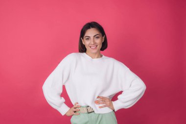 Pembe arka planda beyaz süveter giyen güzel bir kadın tecrit edilmiş kopya alanı