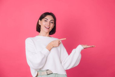 Pembe arka planda beyaz süveterli kadın gülüşü ve izole edilmiş bir kopya alanı.