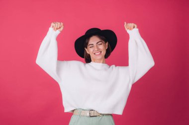 Beyaz süveter ve kırmızı arka planda şapka giyen şık bir kadın. Fotokopi alanı.